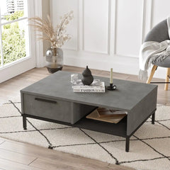 Vue rapprochée de la table basse CALLISTO avec plateau effet béton et pieds acier noir.