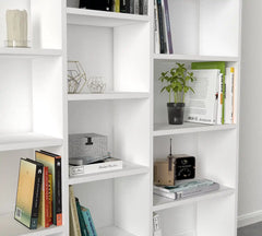 Zoom sur les compartiments de la bibliothèque BIBLIÉLÉGANCE blanche, avec livres, plantes et objets déco pour un intérieur élégant.