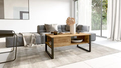 Table basse VALENCE bois clair et acier noir, ambiance salon moderne, parfaite pour salons contemporains avec plateau épais et rangements.
